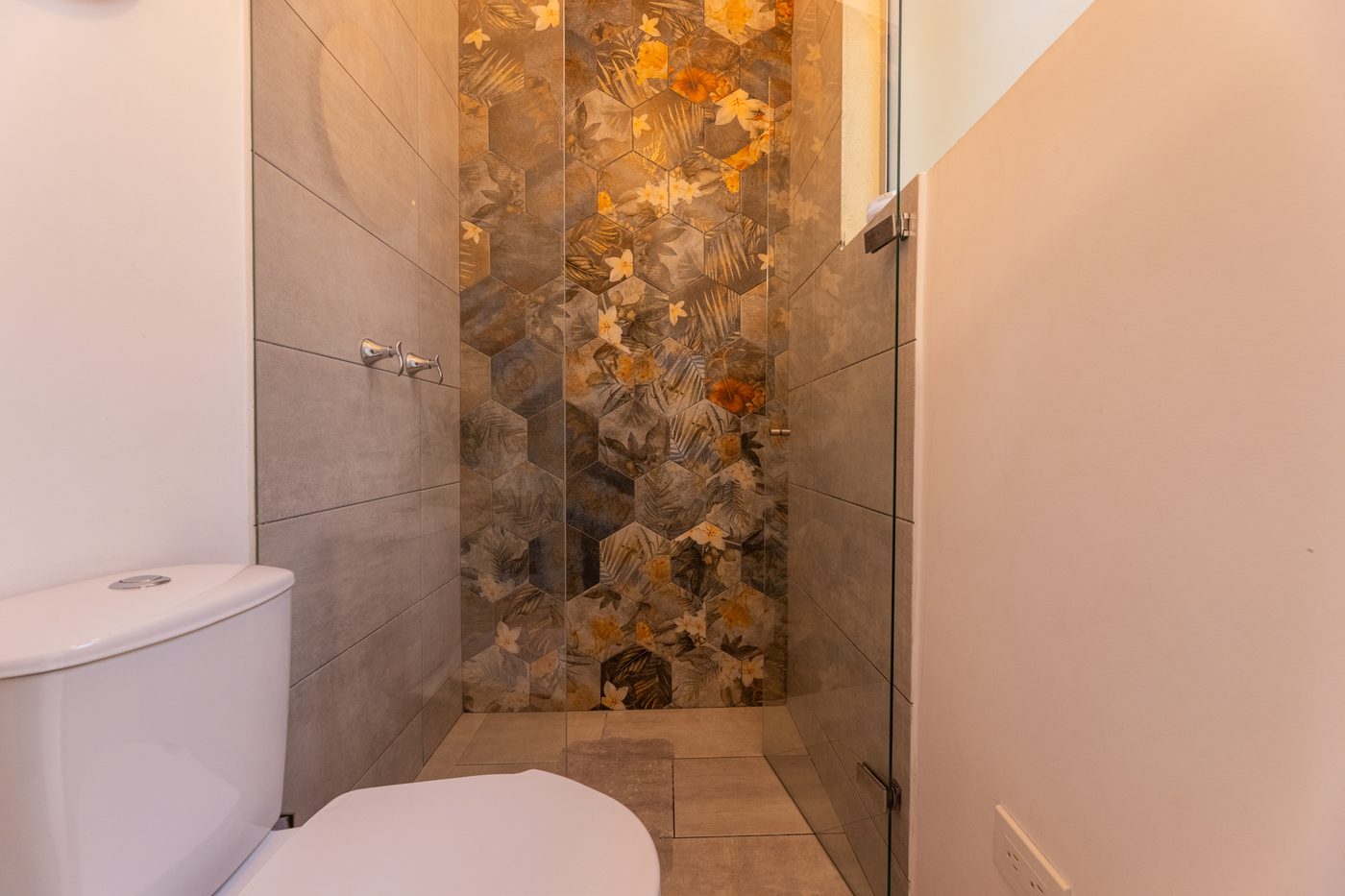 Ducha de Casa Luz con azulejo hexagonal de motivo tropical